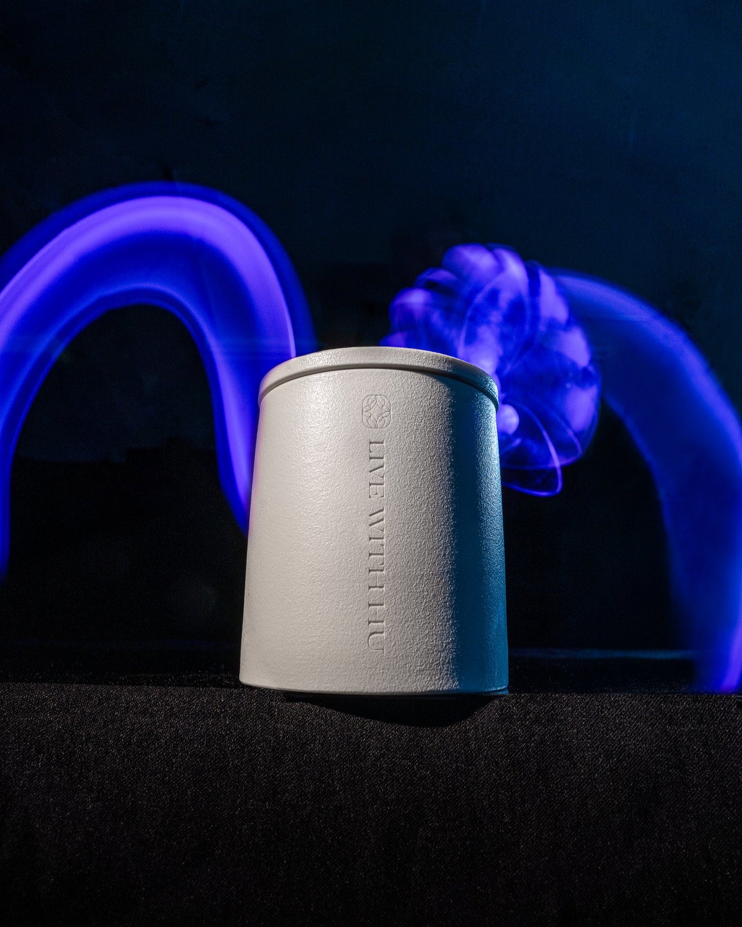 Handcrafted lilac & frankincense candle in a ceramic jar. Lightpainting shot.