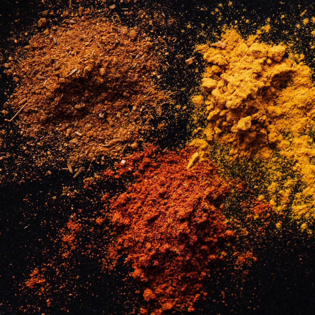 Multiple oriental spices powdering the table in an artistic format. You can smell the heat and warmness from the screen.