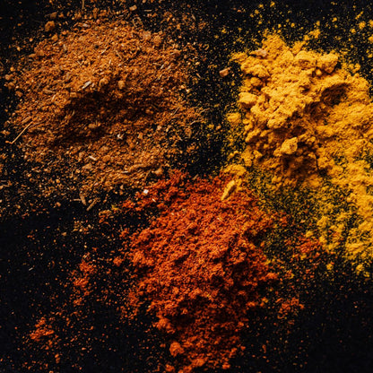 Multiple oriental spices powdering the table in an artistic format. You can smell the heat and warmness from the screen.