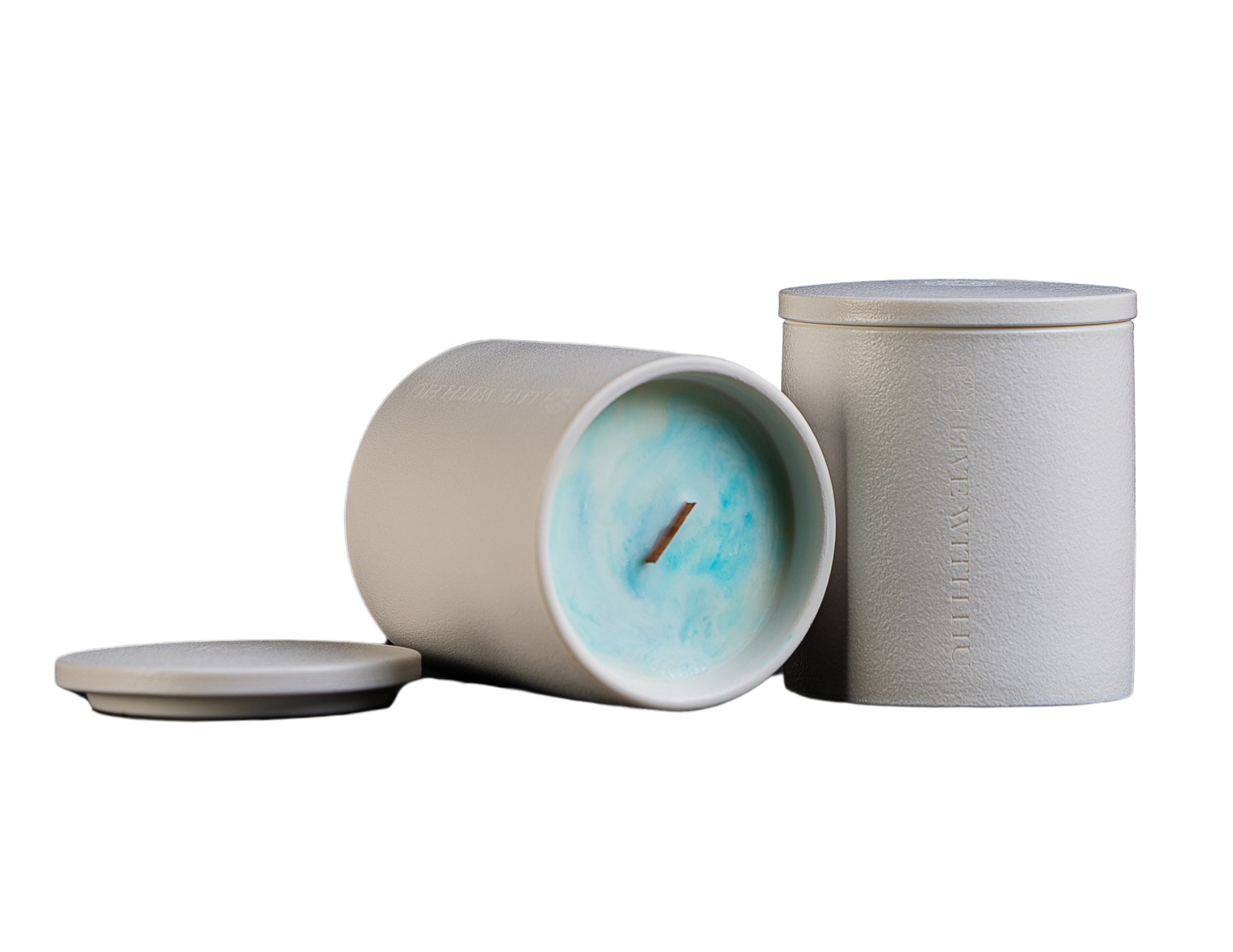 The grace candle in an elegant ceramic jar, showcasing not only the timeless vessel but also the colorful wax inside with an artistic pattern.